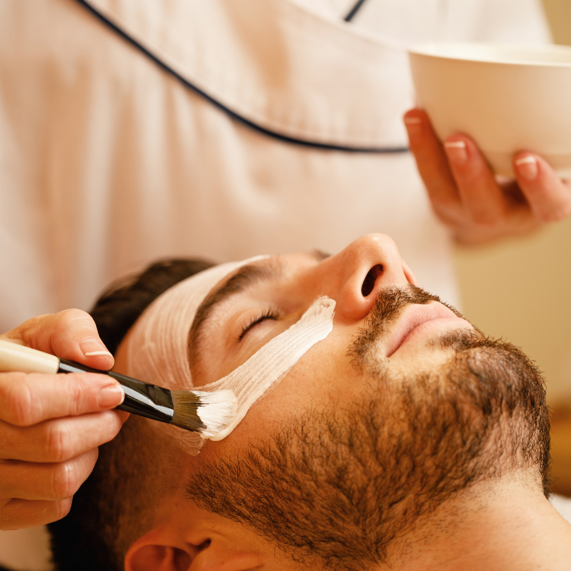 Man receiving a relaxing facial treatment